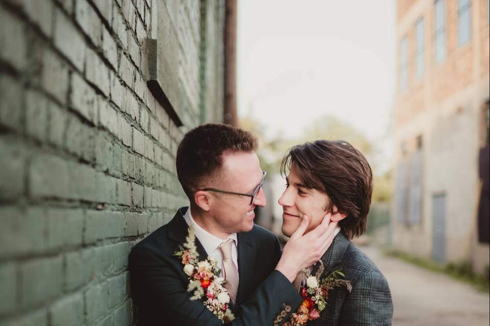 A tender moment by a brick wall