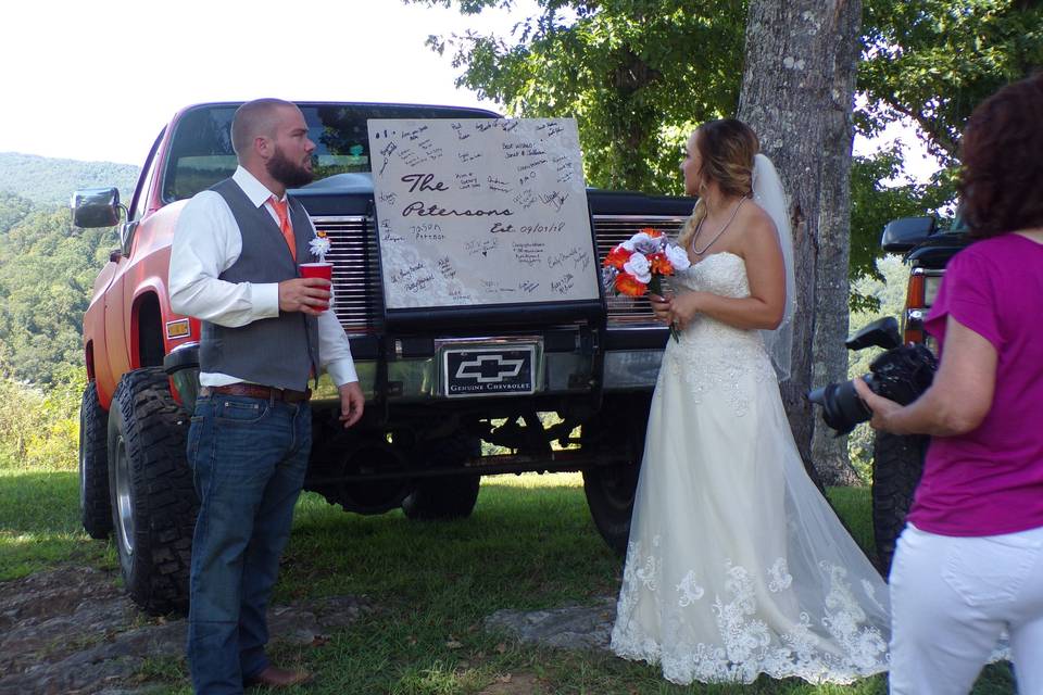 The bride and groom in front of pickup truck