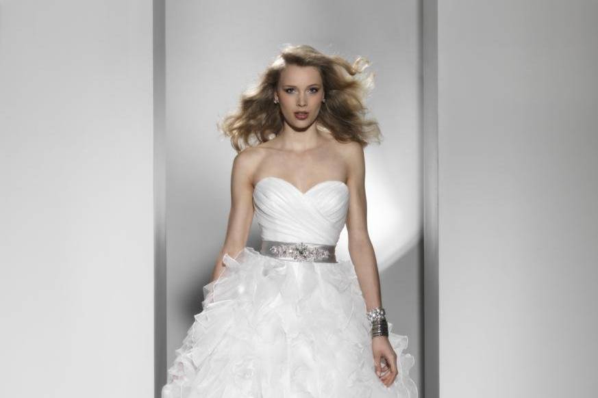 Style 9726A sweetheart neckline is adorned by delicate beading on embroidered lace that cascades into a tulle A-line skirt. The gown has a chapel length train and tulle buttons over the back zipper.