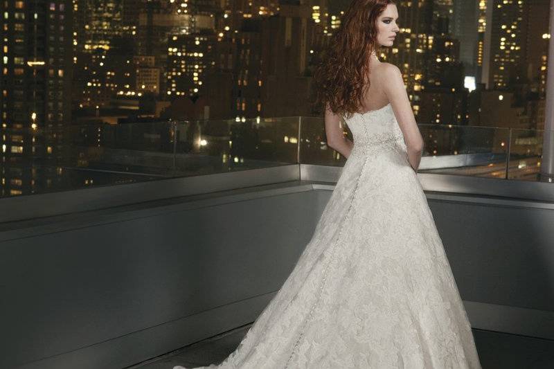Style # 9750Heavily hand beaded organza drop waist bodice featuring a sweetheart neckline on a vertical funnel skirt with organza edging. This gown is finished with a satin covered buttons to the bottom of the basque and a chapel length train.