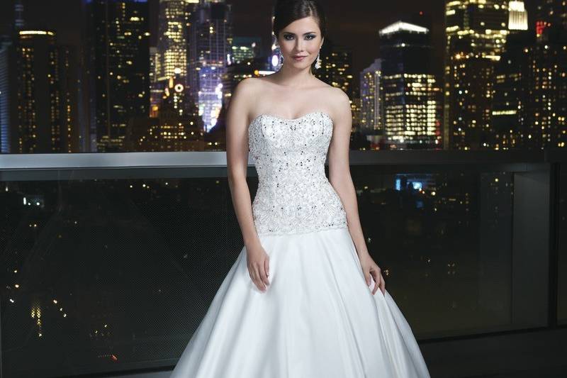 Style # 9749Chantilly lace with hand beaded tulle overlay fit and flare gown with a sweetheart neckline. The gown is finished with satin covered buttons to the end of beading and a chapel length train.