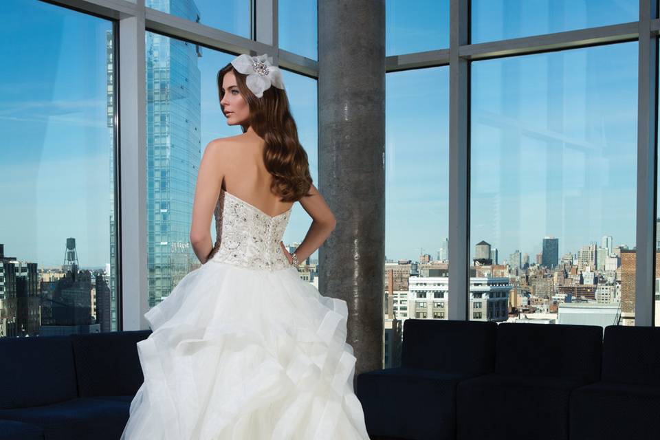 Style 9839 <br> Opalescent crystals and pearls are used for all over adornment on this V-neck fit and flare gown with an illusion back, metallic silk underlay, and chapel length train.