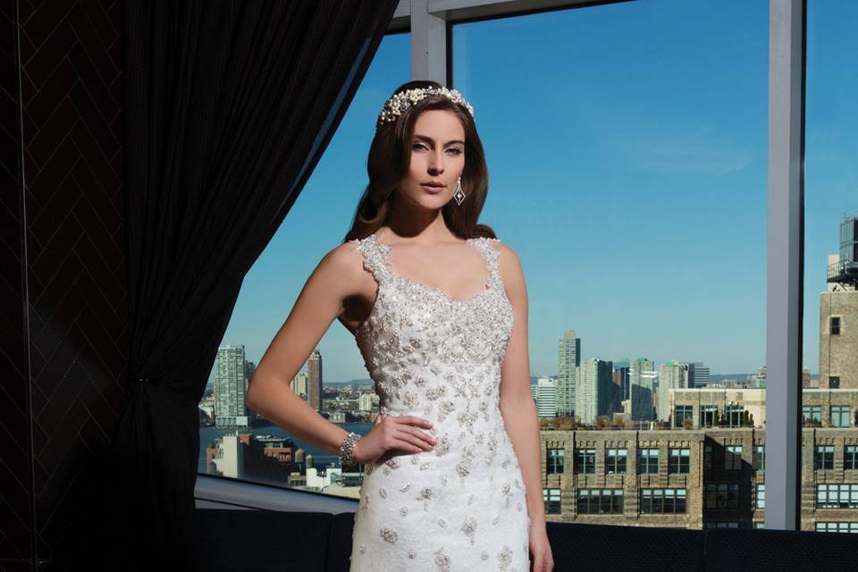 Style 9837 <br> Pearls, crystals, and a sequin pattern heavily adorn the bodice and continue throughout this mermaid gown inspired by blooming florals. The illusion front, natural waistline, and chapel length train make this jersey gown a statement piece.