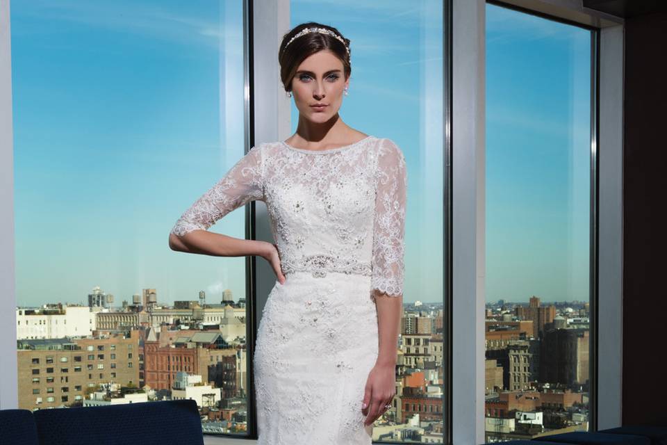 9862		Walk down the aisle in this strapless sweetheart gown with a detachable cathedral length skirt with buttons to the end of the train. The straight silhouette of this gown is perfect to dance the night away in after the ceremony featuring an attached beaded belt and allover lace appliques. Available without the train as style 9862D.