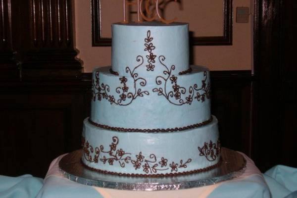 Blue icing with chocolate piping to replicate the lace pattern of the bride's dress with chocolate fudge cake and chocolate mousse filling laced with coffee liqueur to intensify the flavors.