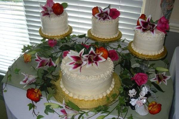 Iced with a special Ivory butter cream each of the small cakes were a different flavor, German chocolate, marble with chocolate filling, and yellow cake with strawberry filling.  The large cake was French vanilla with raspberry fill.  These were topped with fresh flowers arranged by me.