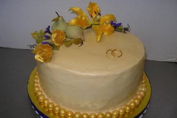 A small family celebration in honor of a couple's 50th Wedding Anniversary.  Gum paste flowers and golden rings entwined top off this gem of a cake.  Buttery yellow cake was filled with vanilla mousse  and covered in silken Italian butter cream.