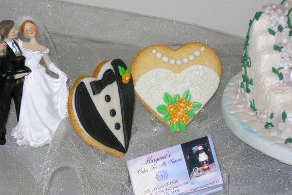 The bride and groom cookies can be made of vanilla or chocolate sugar dough with fondant tux in white or black and bride in white or ivory with flower color matching the wedding colors.  Each one is packaged and tied with matching ribbon.