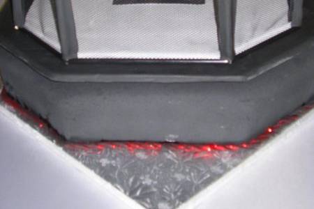 Groom's cake of the Ultimate Fighting Championship cage atop a fondant covered 15 X 17 cake with Bavarian cream filling.  The cage is a permanent keepsake for the groom's collection of fighters.