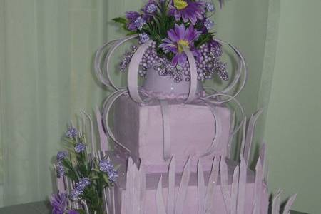 This cake was called the Grassy Meadows cake.  The bride saw a picture in a magazine she liked but the color was green.  She request a change to lavender and it worked well.  The top and sides of the cake was covered in  purple silks and a few edible butterflies.  The spikes are made of gum paste to represent blades of grass.  I think of it as a meadow in twilight.  French vanilla cake with vanilla butter cream filling.