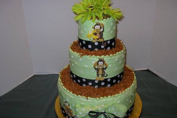 This is a 3 tiered baby shower cake featuring Chico the popular monkey.  It was French Vanilla cake and butter cream filling.  The polka dots in the icing were gum paste and the ledges were lined with coconut.