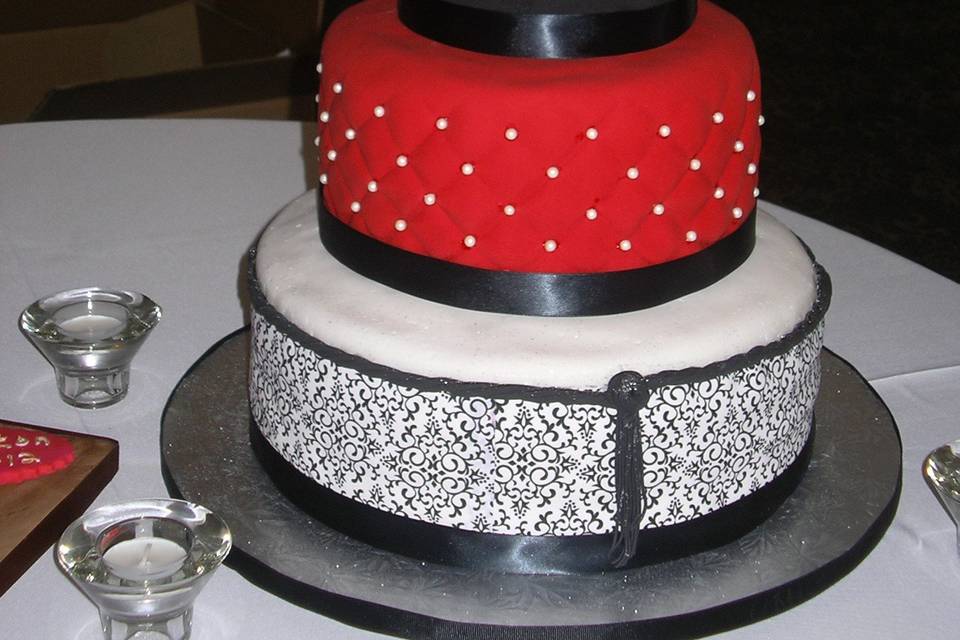 This cake was red, white and black fondant covering French Vanilla cakes.  The groom made the topper to match the theme.