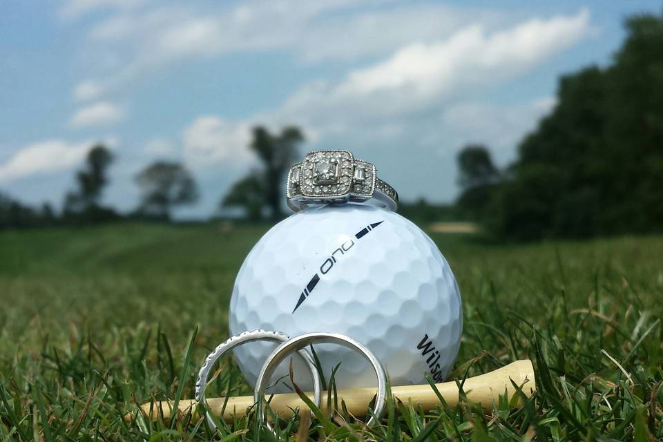 Wedding bands, golf ball and tee