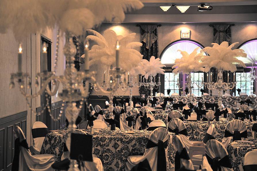 As you step into your wedding reception, your wedding centerpiece decorations look like they're bursting into white elegant clouds when the reception table are decorated with white ostrich feathers in fronsted vases. Presented by Kims Bridal and Gifts.