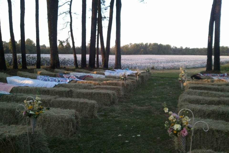 The couple exchanged vows in front of a beautiful cotton field on their property. Hay bails and the grandmother's hand made quilts were brought in for wonderful rustic comfort.