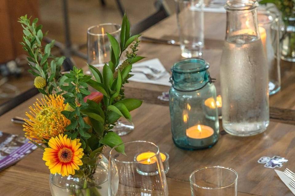 Rustic, vintage style courtesy of Ardent Forager mixed with bright local flowers and warm candle light.