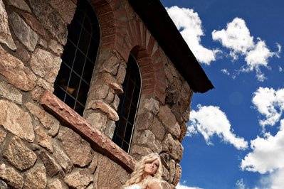 Bride standing on a side of a rock church