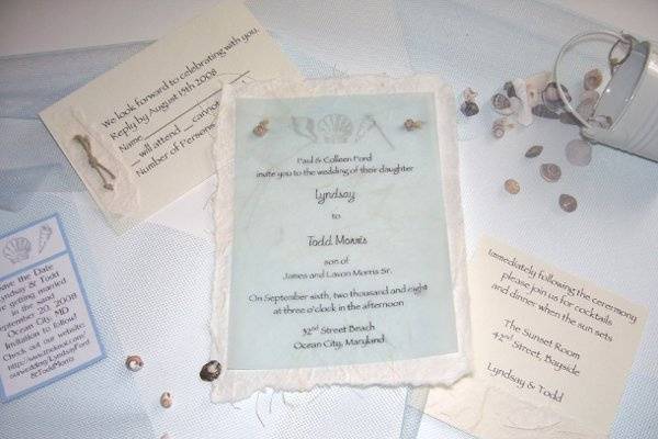 The Knot
What a beautiful invitation for your beach wedding! The invitation is printed on a delicate piece of light blue vellum and attached to a piece off white handmade paper with hemp knots. The beautifully rich handmade paper has torn edges and shows subtle hints of grass and leaves.