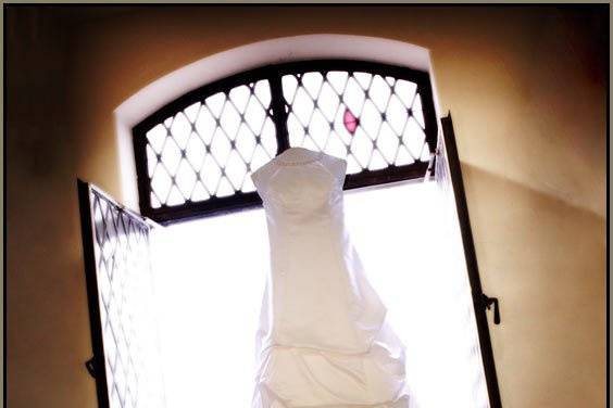 Bride's dress hanging in window, backlit, Indianapolis Scottish Rite Cathedral.