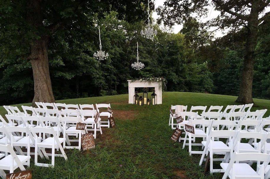 Chandeliers, fireplace mantle and white wedding chairs
