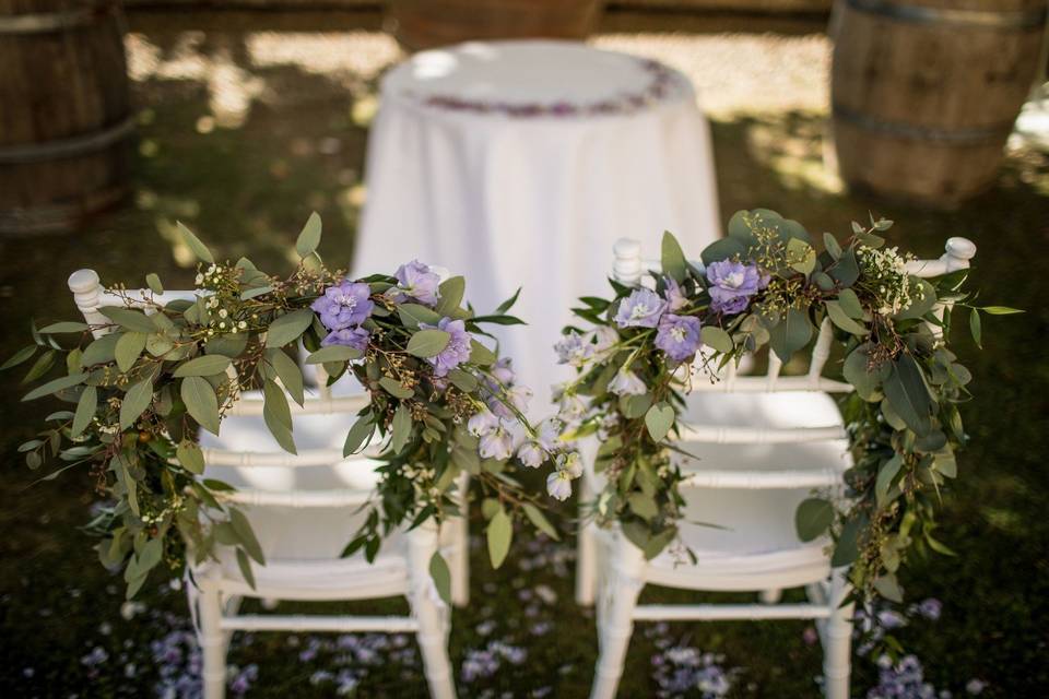 Decorations with olive an greenery for the bride and groom's chairs
