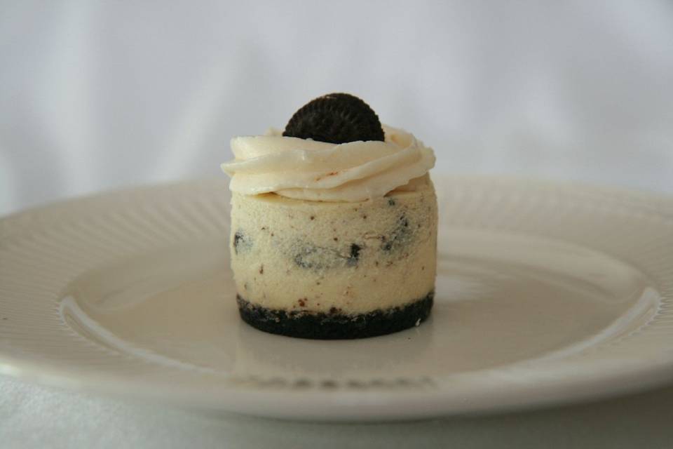 Cookies N Cream - Rich and Creamy Cheesecake, filled with Oreo Pieces, topped with vanilla butter cream and finished with an Oreo crust.