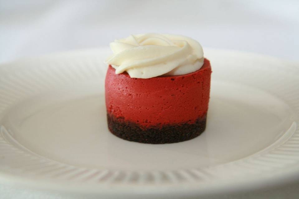 Red Velvet Cheesecake - Rich Creamy Red Velvet Cheesecake, topped off with a vanilla butter cream, finished with a chocolate crust