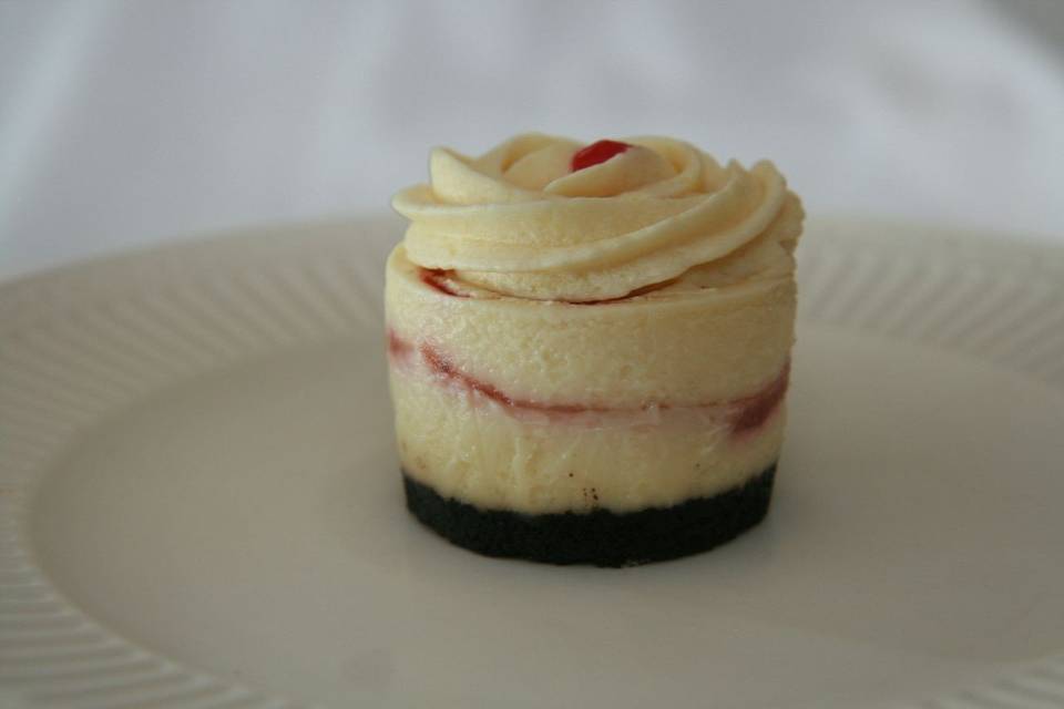 White Chocolate Raspberry Cheesecake - Rich Creamy White Chocolate Cheesecake with fresh raspberry sauce swirled throughout, finished with a chocolate crust