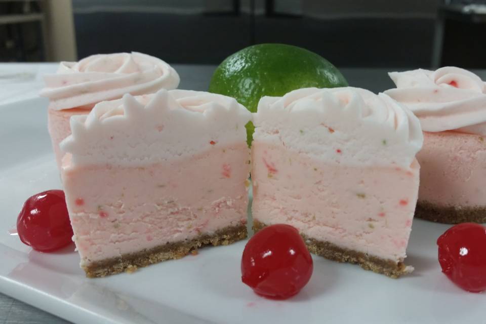 Cherry Limeade Cheesecake - Perfect for a Summer Event. Creamy Cherry and Lime cheesecake topped with a Cherry and Lime Buttercream and finished with a vanilla wafer crust.
