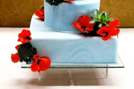 Blue wedding cake with red flowers