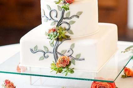 White wedding cake with the newlyweds' figurines on top