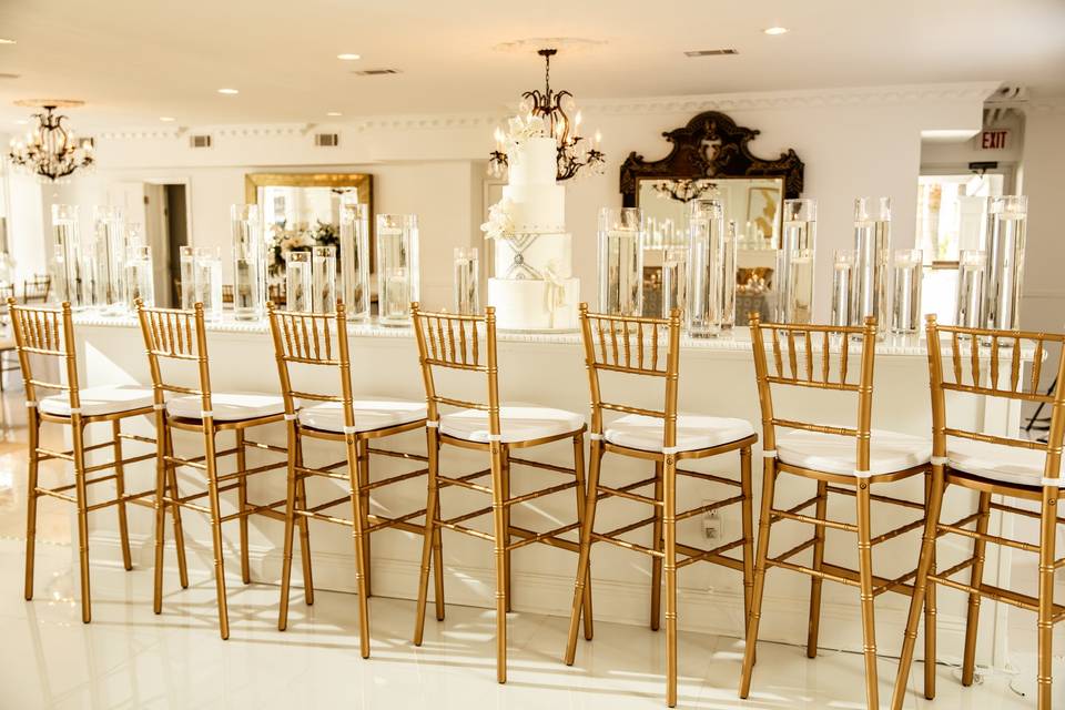 Golden high chair with white linen long table set up