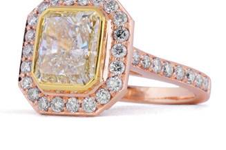 Bezel set fancy yellow radiant cut diamond engagement ring in rose and yellow gold, with diamond halo and side diamonds. Total carat weight 2.00 ct