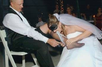 Reversal. Bride putting the garter on her husband. Not so easy.