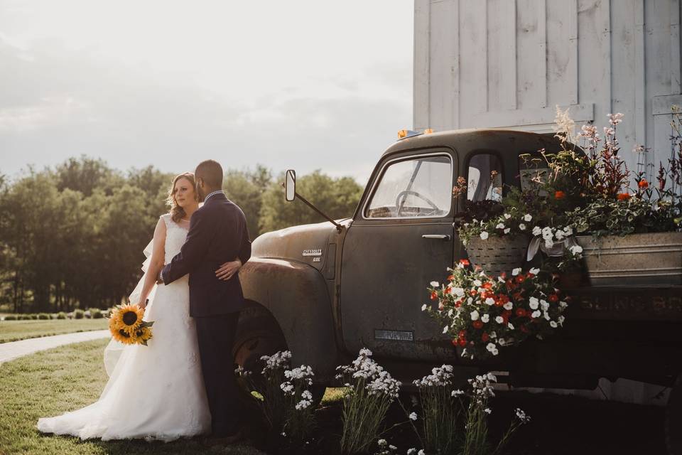 Newlyweds by the truck of flowers