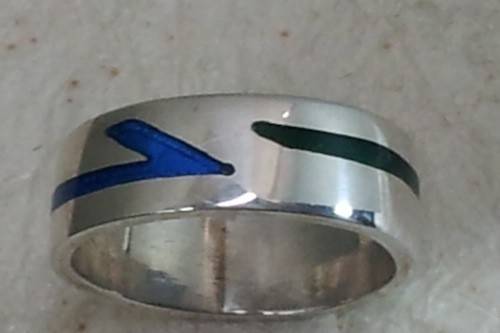 Arrow inlay ring.  6m wide flat band with a bright blue and green ceramic resin inlay. 14kt white gold.