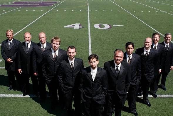 A 40 year sports nut groom with his groomsmen on the 40 yard line of a football field in Salinas