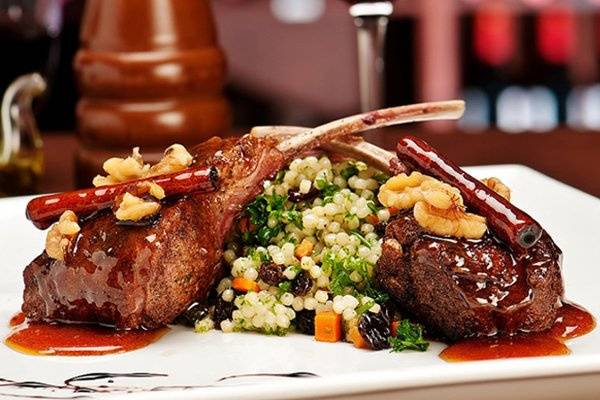 Lamb Chops with Couscous and Vegetables Dressed in a Caramel Pepper and Spice Glaze.