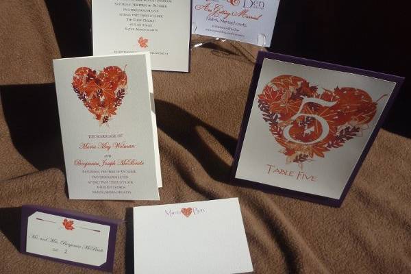 We custom created a heart of fall foliage for this October bride using her colors of aubergine and orange to connect everything from the save-the-date to invitation to program and table numbers.
