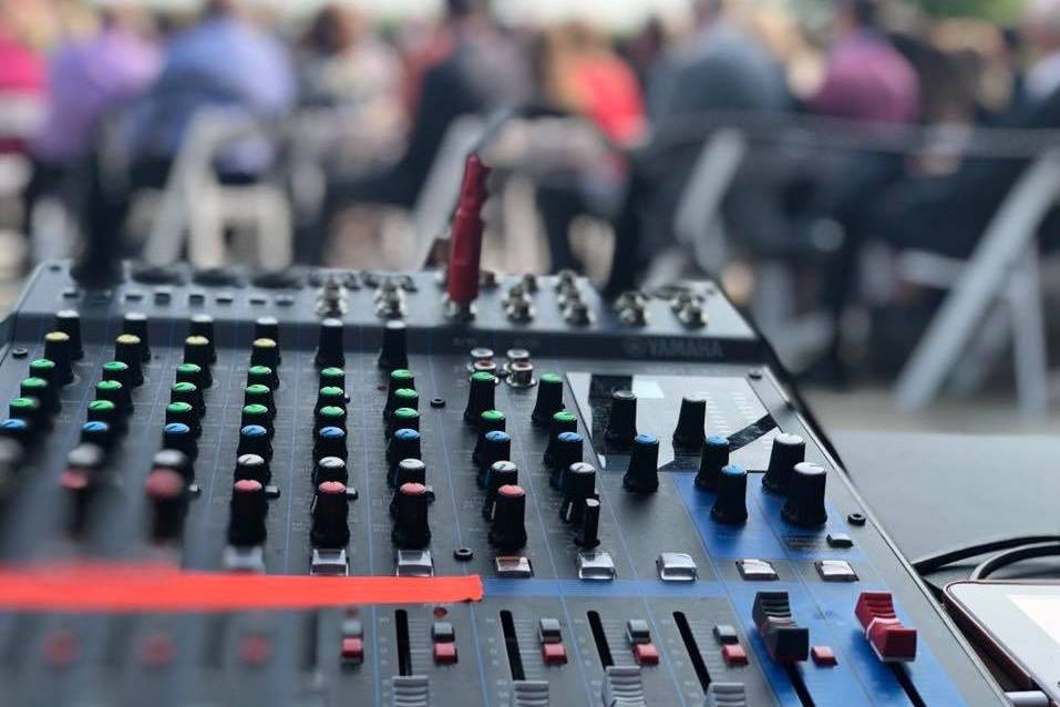 DJ booth setup in front of a piano