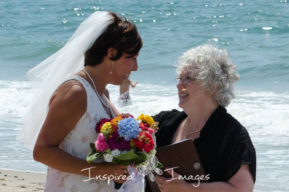 CT officiant Zita Christian shares a word with the bride on the beach in RI | Photo by Inspired Images