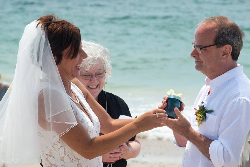 CT officiant Zita Christian guides Leslie and Chuck in a wedding ritual blending sand from significant places, including this RI beach | Photo by Inspired Images.
