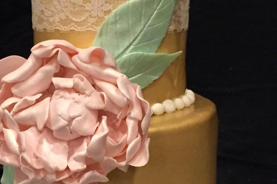 Golden brushed lace cake with handmade pink peony flower. Adorned with edible lace and pearls