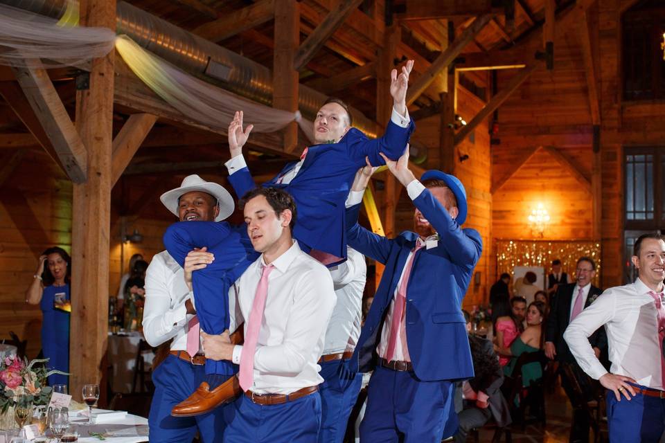 Groomsmen carry groom