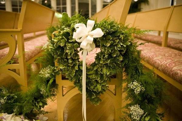 Garland draped from pews with heart-wreaths