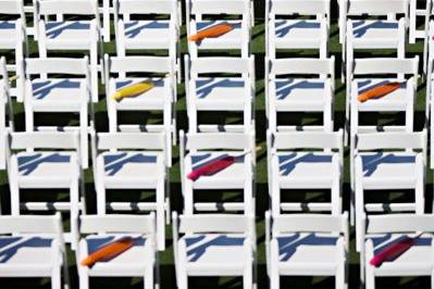 Colorful parasols to shade guests pop off these white ceremony chairs