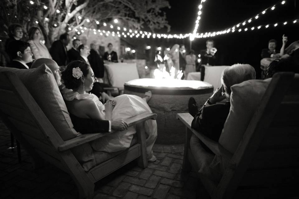 Bride & groom relaxing with guests under the stars and around the fire