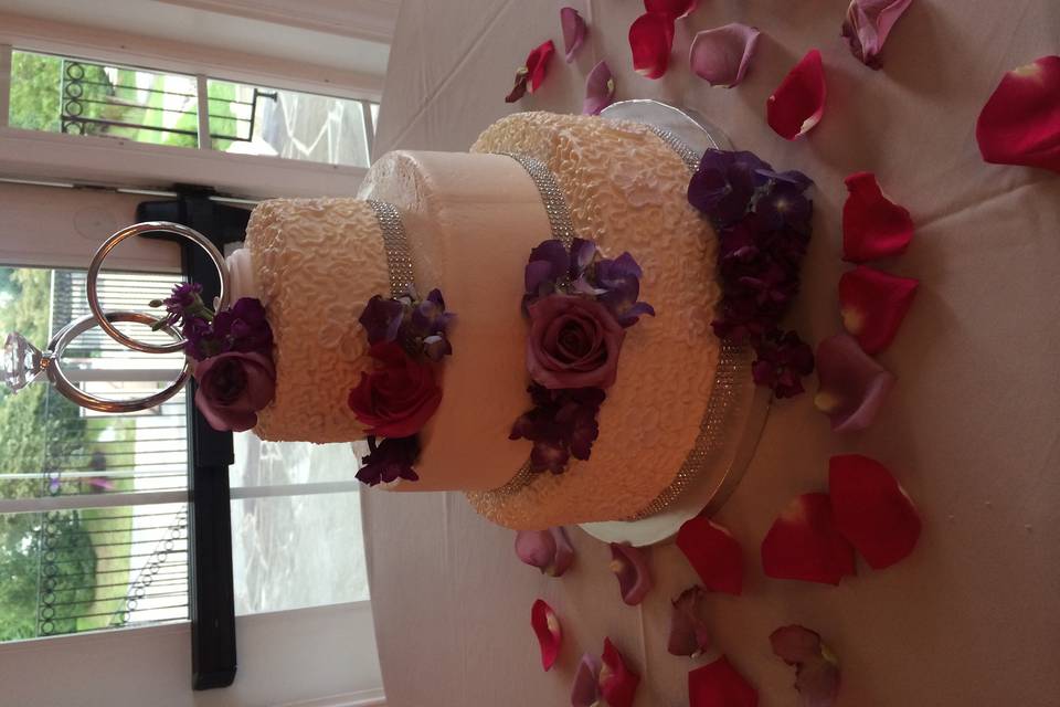 3-tiered buttercream, fresh flowers, rhinestone base ribbons