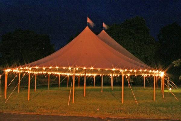 Under a Century pole tent with custom flooring, lighting and decor.