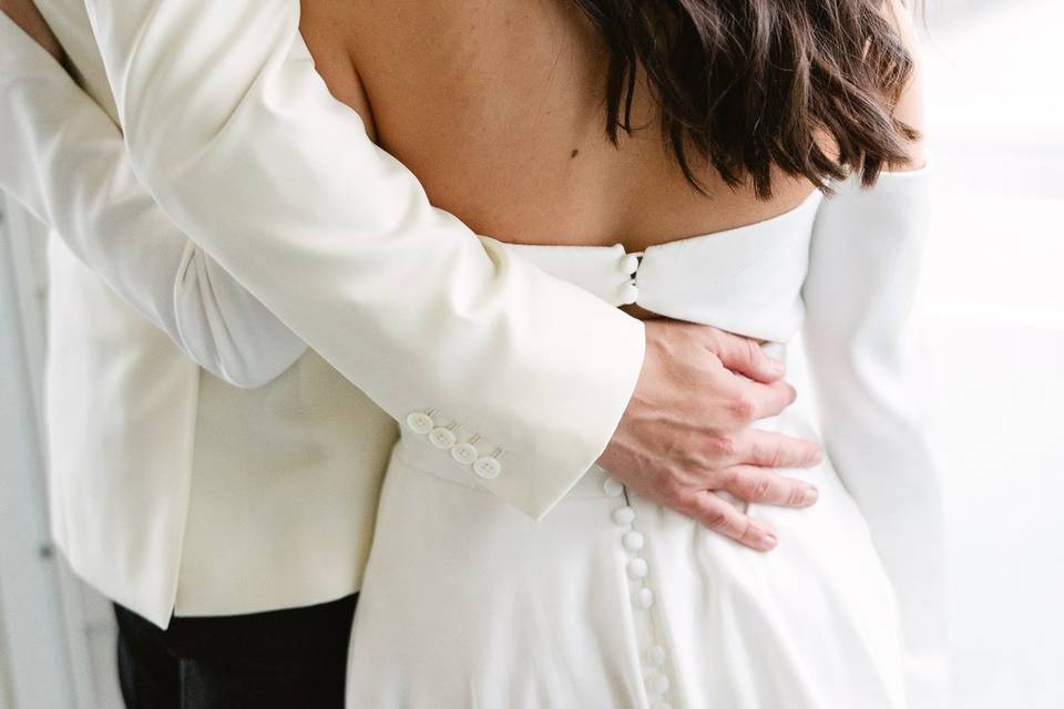 Couple jumping on bed in wedding attire